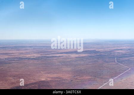 Luftlandschaft mit C15-Feldweg in der kargen Kalahari-Wüste, aufgenommen von einem Segelflugzeug im hellen Licht des späten Frühlings in der Nähe von Uhlenhorst, Namibia, Afrika Stockfoto