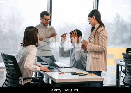 Das Meeting abhalten. Vier Personen arbeiten zusammen im Büro. Stockfoto