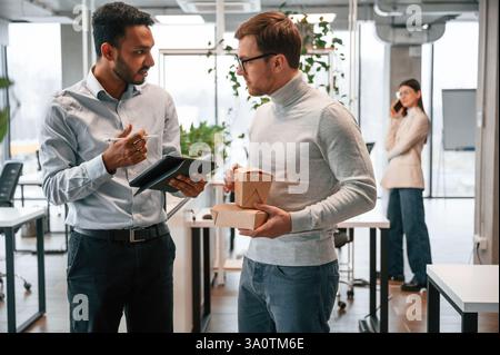 Geschäftsgespräche führen. Männer und Frauen arbeiten zusammen im Büro. Stockfoto