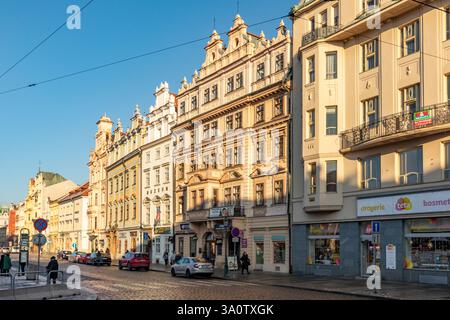 Pilsen, Tschechische Republik - 2. Januar 2020: Alte historische Straße mit alten Gebäuden im Winter in der Altstadt von Pilsen mit Parkplätzen im Schnee. Stockfoto