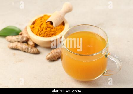 Aromatischer Kurkuma-Tee, Rhizome und Pulver auf weißem texturiertem Tisch, Nahaufnahme Stockfoto