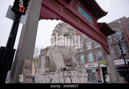 Steinlöwe steht am Eingang von Chinatown, unter dem kunstvollen traditionellen chinesischen Tor Stockfoto