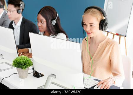Multiethnische Callcenter-Betreiber mit Headsets sprechen online mit Kunden Im modernen Büro Stockfoto