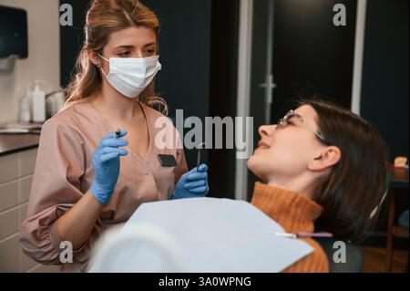 Die junge Frau sitzt auf dem Stuhl. Im stomatologischen Schrank. Stockfoto