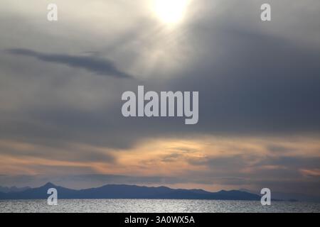 Sonnenuntergang über Inseln in der Ägäis vor Vouliagmeni Beach Athen Attika Griechenland Stockfoto