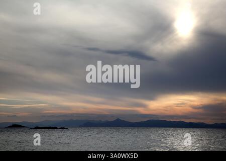Sonnenuntergang über Inseln in der Ägäis vor Vouliagmeni Beach Athen Attika Griechenland Stockfoto