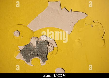 Risse in der Farbe an der gelben Wand Stockfoto