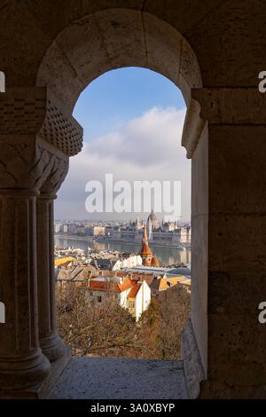 Blick durch einen der Bögen der Fischerbastei in Richtung Donau und Budapest, Ungarn mit Blick auf das ungarische Parlamentsgebäude Stockfoto