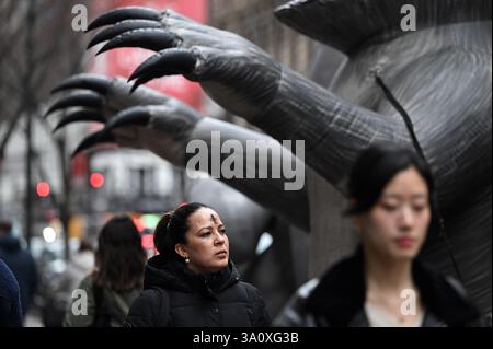New York, USA. März 2025. Eine Fußgängerin läuft an einer aufblasbaren Ratte mit einem Kreuz aus schwarzer Asche auf der Stirn vorbei, während Katholiken Aschermittwoch, New York, NY, 5. März 2025 feiern. Der Aschenmittwoch beginnt mit der Fastenzeit, der 40-tägigen Bußzeit vor Ostern, in der Christen die Auferstehung Christi von den Toten feiern. (Foto: Anthony Behar/SipaUSA) Credit: SIPA USA/Alamy Live News Stockfoto
