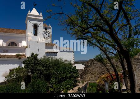 Glockenturm und Uhrenturm der Kirche Santa Maria do Castelo in der Altstadt der schönen Stadt Tavira in A Stockfoto