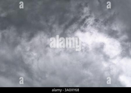 Eine filmische Ansicht eines grauen Himmels voller wirbelnder Wolken, die ein Gefühl von Drama und Vorfreude wecken. Perfekt für Stimmung und Wetter. Stockfoto