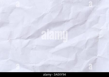 Nahaufnahme einer zerknitterten weißen Papierstruktur, perfekt für Hintergründe in Designprojekten. Die dezenten Falten sorgen für ein haptisches und künstlerisches Aussehen. Stockfoto