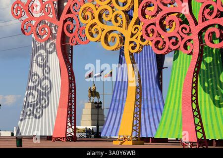 Bunte LED-Lichtmetallbäume in der Nähe der Plaza Nicaragua am Ufer des Managua-Sees mit dem Denkmal von Simon Bolivar im Hintergrund. Managua. Nicaragua Stockfoto