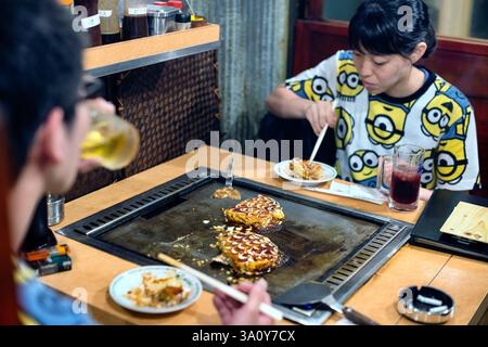 KUNDEN AUS DER PRÄFEKTUR KANAGAWA GENIESSEN am 20. Juli 2017 Okonomiyaki-Pfannkuchen im Hauptgeschäft von Boteju in Osaka, Japan Stockfoto