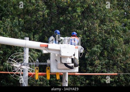 BOGOTA, KOLUMBIEN - 5. MÄRZ 2025 ein paar Energiearbeiter an der Spitze eines Leuchtturms, die Wartungsarbeiten durchführen Stockfoto