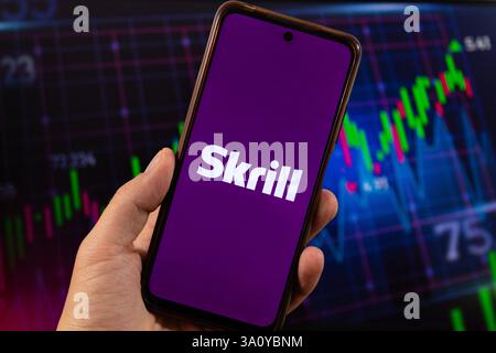 BOGOTA, KOLUMBIEN - 05. MÄRZ 2025 ein Smartphone mit skrill-App und verschwommenem Finanzierungskonzept im Hintergrund Stockfoto