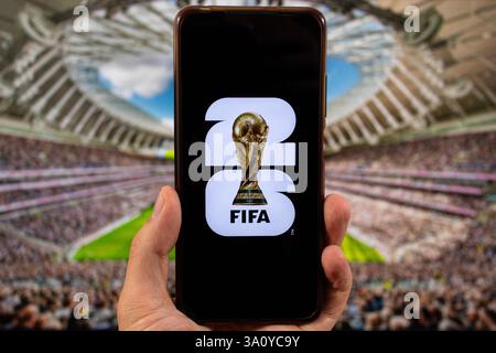 BOGOTA, KOLUMBIEN - 5. MÄRZ 2025 ein Smartphone mit fifa-WM-Logo und verschwommenem Stadion im Hintergrund Stockfoto