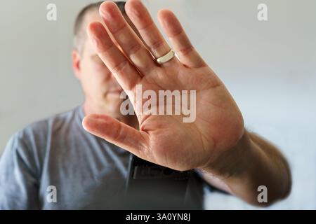 Datenschutzkonzept mit Handyhalter und Handbedeckung des Gesichts Stockfoto