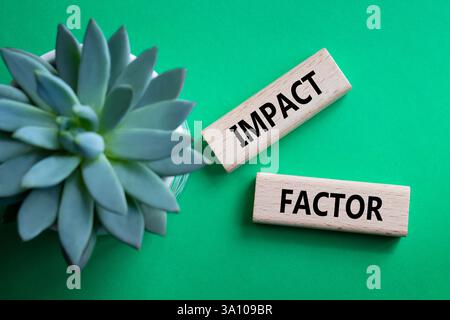 Symbol für Aufprallfaktor. Holzblöcke mit den Worten Impact Factor. Schöner grüner Hintergrund mit saftiger Pflanze. Business and Impact Factor Konzept. Cop Stockfoto