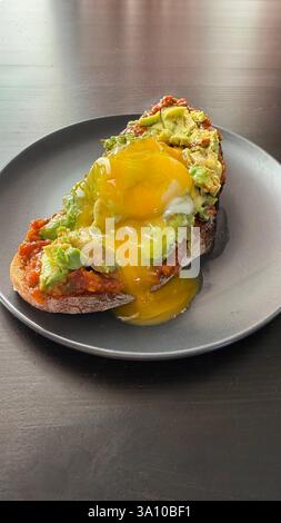 Gesundes Sandwich mit Avocado und pochierten Eiern. Gesundes Ernährungs- und Ernährungskonzept. Stockfoto