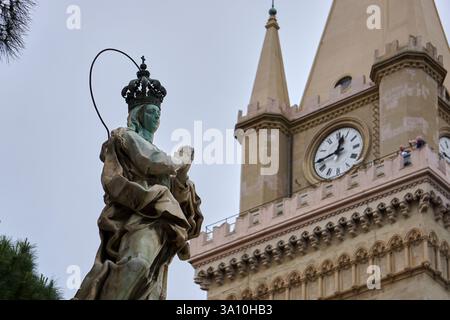 Statue der Unbefleckten Empfängnis mit dem astronomischen Uhrturm der Kathedrale von Messina im Hintergrund, Messina, Sizilien, Italien. Stockfoto