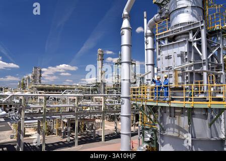Gruppe von Arbeitnehmern Berufsausrüstung in einer Erdölraffinerie - moderne Gebäude und Industrieanlagen für die Brennstoff- und Gasproduktion Stockfoto