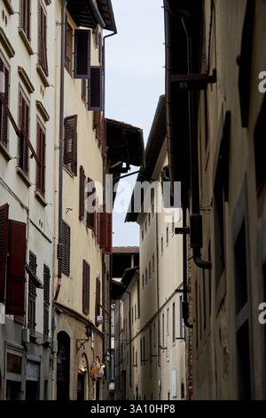 Enge historische Gasse mit traditionellen hohen Gebäuden und Holzläden in Florenz, Toskana, Italien Stockfoto