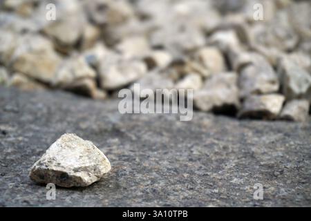 Kleine Steine in Hellbeige und weiß in Nahaufnahme, Kies, robuste Hintergrundstruktur. Unregelmäßig geformte, helle Steine Stockfoto