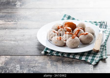 Papas Arrugadas mit Mojo auf Holztisch. Traditionelles kanarisches Essen. Stockfoto