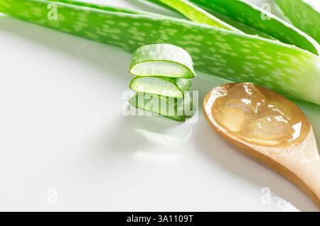 Aloe Vera Gel Nahaufnahme. Geschnittene Aloe Vera Pflanzen Blatt und Gel mit Holzlöffel, natürliche Bio-kosmetische Inhaltsstoffe für empfindliche Haut Stockfoto
