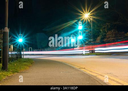 Niedrigwinkelaufnahme mit grünen Ampeln und Straßenpfaden bei Nacht Stockfoto
