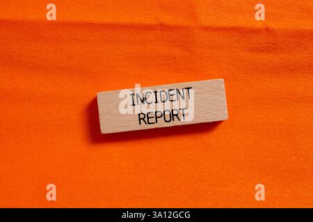 Meldung zum Vorfall auf Holzblock auf orangem Hintergrund geschrieben. Symbol für den konzeptionellen Vorfallbericht. Kopierbereich. Stockfoto