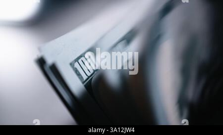 Geldzählmaschine Bankmaschine Nahaufnahme. Makroansicht Zählmaschine, die 100 US-Dollar-Scheine zählt. Konzept des Geldes. Stockfoto