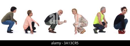 Seitenansicht einer Gruppe von Mann und Frau, die auf weißem Hintergrund hocken Stockfoto