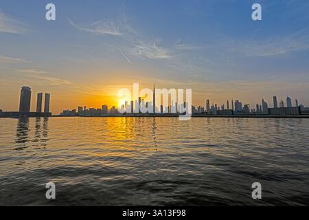 Panoramablick auf die Skyline von Dubai bei Sonnenuntergang mit Burj Khalifa und Wasserreflexionen im Winter Stockfoto