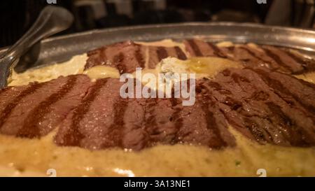 Das brausende gegrillte Rinderfilet-Steaks wird mit einer cremigen Sauce und einem Klecks Butter serviert und sorgt für ein verführerisches kulinarisches Erlebnis Stockfoto