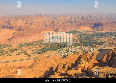 Atemberaubender Panoramablick vom Harrat Aussichtspunkt aus auf die weite Wüstenlandschaft, die Oase der Altstadt von Alula und den umliegenden Sandstein Stockfoto