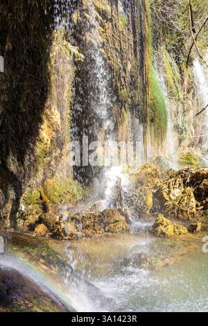 Mehrere Wasserfälle fließen sanft über moosbedeckte Felsen in einen ruhigen Pool. Üppiges Grün umgibt die Gegend und schafft ein friedliches Ambiente in natura Stockfoto