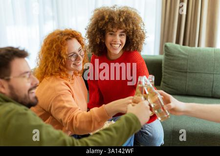 Eine Gruppe fröhlicher Freunde versammelt sich in einem stilvollen Wohnzimmer, teilt Getränke und genießt die Gesellschaft der anderen an einem sonnigen Nachmittag. Lachen erfüllt Stockfoto