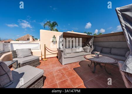Ein Bild von verschiedenen Stühlen und überdachten Sofas auf der sonnigen mediterranen Dachterrasse Stockfoto