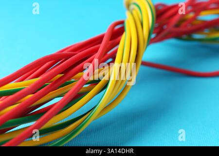 Viele farbige elektrische Drähte auf hellblauem Hintergrund, Nahaufnahme Stockfoto
