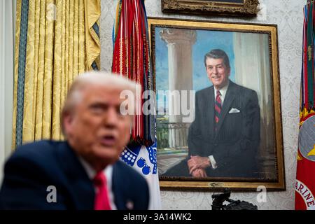 Washington, DC, USA. März 2025. Ein Porträt des ehemaligen US-Präsidenten Ronald Reagan als US-Präsident Donald Trump am Donnerstag, den 6. März, im Oval Office des Weißen Hauses in Washington, DC, USA, spricht. 2025. Trump unterschreibt Befehle, die Zölle auf USMCA-Handel aus Kanada und Mexiko bis zum 2. April auszusetzen. Quelle: Al Drago/Pool über CNP/dpa/Alamy Live News Stockfoto