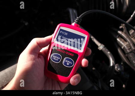OBD- oder OBD-II-Scanner im Einsatz durch Techniker, Kfz-Diagnosewerkzeug zum Scannen von Fehlercodes des Motorsystems im Auto, Autoreparaturkonzept Stockfoto