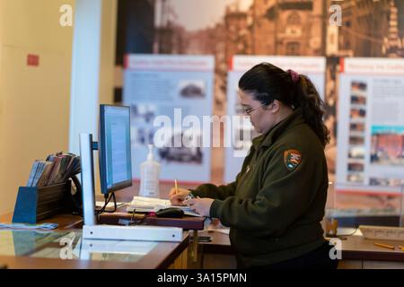 Seattle, Washington, USA. März 2025. Ein National Park Ranger arbeitet am Besucherschalter des Klondike Gold Rush National Historical Park in Seattles Pioneer Square. Seattles Einheit des Klondike Gold Rush National Historical Park, untergebracht im Wahrzeichen Cadillac Hotel, ist eines von 34 Park Service Pachtverträgen, die die Trump-Regierung annulliert hat. Quelle: Paul Christian Gordon/Alamy Live News Stockfoto
