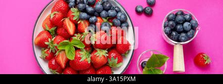 Frische Erdbeeren auf rosafarbenem Hintergrund. Das Konzept der Bio-Lebensmittel. Draufsicht. Panorama. Stockfoto