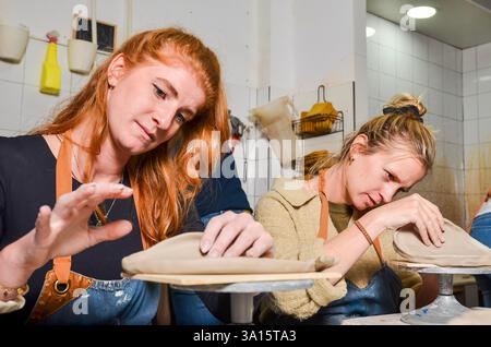 Zwei Handwerker, die in einem Keramikstudio mit Ton arbeiten, Formen und Formen von Rohstoffen Stockfoto