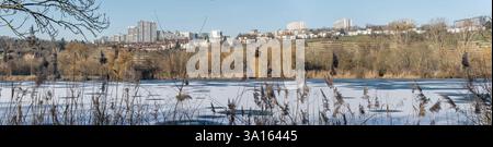 Moderne mehrstöckige Wohnhäuser und gefrorenes Wasser am Max-Eyth-See. Aufgenommen in hellem Winterlicht in Stuttgart, Baden Wuttenberg, Germa Stockfoto