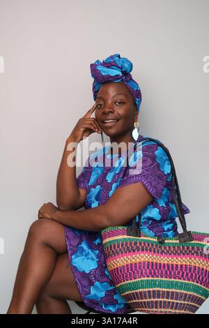 Stilvolle schwarze Frau posiert mit farbenfrohem afrikanischem Kleid und Kopfbedeckung Stockfoto