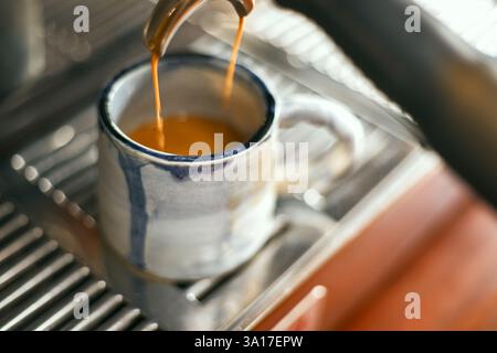 Nahaufnahme der Kaffeemaschine beim Ausgießen von Espresso im Café, selektiver Fokus Stockfoto