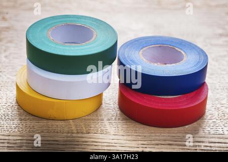 Fünf farbige Rollen Isolierband auf Holzbrettbaukonzept Stockfoto